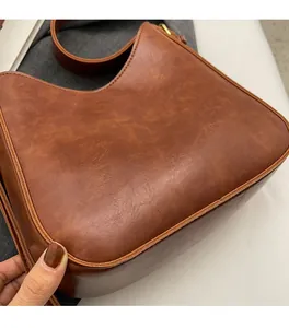 Macro detail of caramel brown bucket bag showing retro texture and soft PU leather material