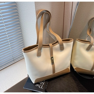 Detail of large tote bag with gold lock and cream-brown color block design