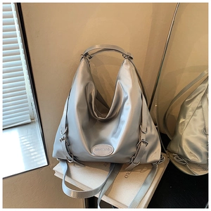 Dettaglio della borsa tote argento metallizzato con logo del marchio in un set lifestyle
