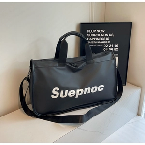 Close-up of black travel bag with Suepnoc logo on marble table and removable strap