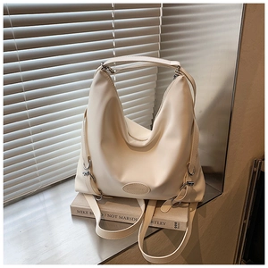 Dettaglio della tracolla regolabile e fibbia argento su una borsa hobo beige