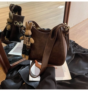Detail of dark brown vintage bucket bag with a cute plush rabbit charm decoration