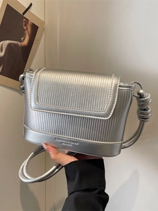 Silver metallic square crossbody bag with vertical stripe texture and flap closure