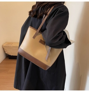 Detail of a two-tone PU leather tote bag with stylish long straps for shoulder or hand carry
