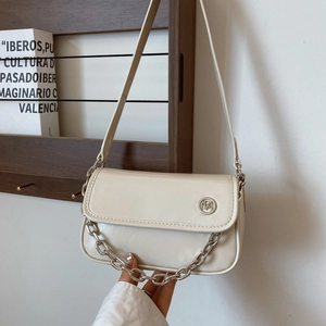 Close-up of cream PU leather flap bag featuring a silver chain and metal emblem