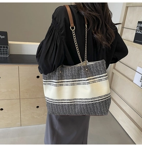 Detail of a large woven tote bag with chain strap and retro color-block texture