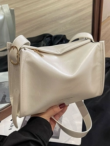 Sac bandoulière en similicuir crème avec bandoulière large et boucles dorées élégantes