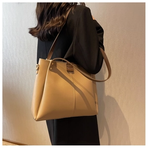 Detail of khaki leather bucket bag showing vertical stitching and elegant brand logo