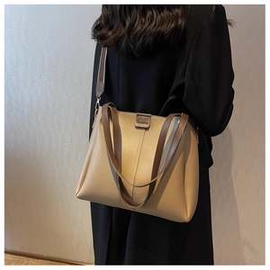 Detail of khaki large tote bag with dark brown wide strap and gold hardware accents