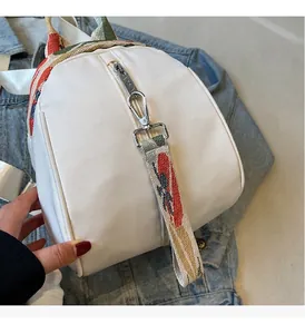 Gros plan du mini sac à dos blanc avec quincaillerie argentée et bandoulière jacquard
