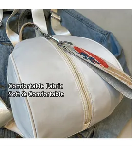Gros plan sur le tissu blanc texturé du sac à dos avec fermeture et poignée tressée