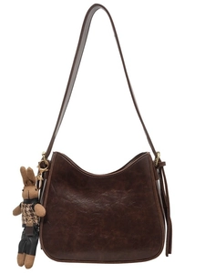 Dark brown retro hobo bucket bag with a cute plaid rabbit charm on white background