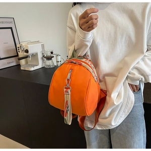 Détail du sac à dos en nylon orange vif avec des bretelles tissées à fleurs en jacquard