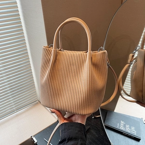 Vista dettagliata della borsa a secchiello beige con trama a pieghe e ganci in argento