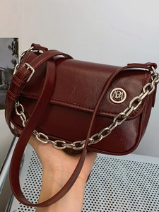 Chic burgundy faux leather crossbody bag with glossy wrinkled texture and silver chain strap