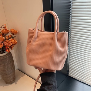 Dettaglio borsa a secchiello rosa pallido con texture a pieghe e tracolla sottile