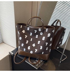 Détail du sac cabas en toile avec patchwork en cuir marron et imprimé à motifs chiffrés