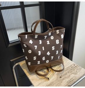 Détail du sac cabas en toile avec imprimés chiffres blancs et anses en similicuir brun