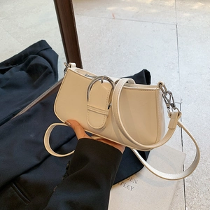 Detail of white PU leather underarm bag featuring a silver horseshoe metal buckle