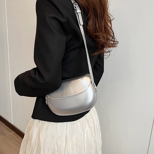 Détails du sac selle argenté avec finition perlée et bandoulière réglable