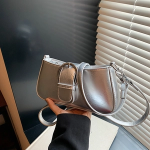 Detail of silver metallic shoulder bag with large circular buckle in modern chic style