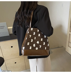 Vue portée d'un sac cabas marron avec motif de chiffres blancs et sangles en cuir