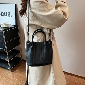 Borsa a secchiello retrò in pelle nera con tracolla larga e trama goffrata chic
