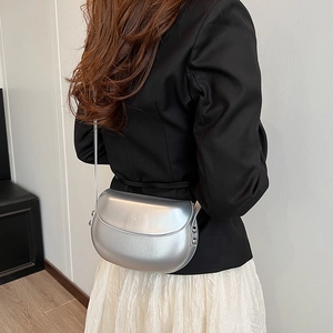 Détail d'un sac besace argenté effet métallisé avec rivets latéraux sur un mannequin