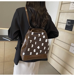 Vue arrière d'un sac à dos marron avec imprimés chiffres blancs porté par un mannequin