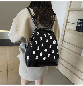 Vue détaillée du sac à dos en toile noire avec imprimé numérique et base en cuir verni