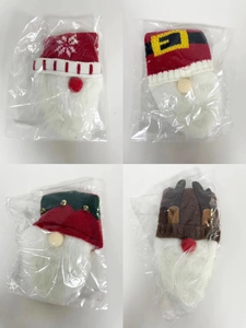 Close-up of four festive Christmas wine bottle covers with knit caps and white faux fur beards