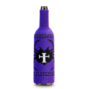 Close-up of purple knitted wine bottle cover with black insect pattern and cross detail