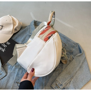 Gros plan du sac de selle blanc avec sangle brodée colorée et détails métalliques