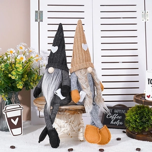 Detail of coffee gnomes with knit heart hats and long legs on a white pedestal