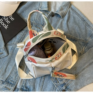 Détail intérieur du sac blanc montrant le rangement pour portable et accessoires