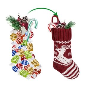 Red Christmas stocking with reindeer and snowflake patterns filled with festive candy gifts