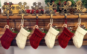 Details von gestrickten Weihnachtssocken mit Schneeflockenhaken und Festdeko
