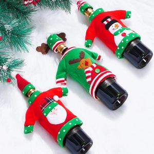 Dettaglio dei copribottiglie di vino lavorati a maglia con Babbo Natale, renna e pupazzo di neve