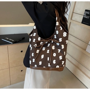Detail of deep brown canvas tote bag with white number prints and drawstring bow detail