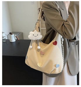 Borsa tote in tela beige con toppe a cuore colorate e ciondolo a nuvola in peluche