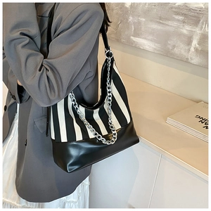 Detail of striped canvas and black leather stitching with a silver metal chain