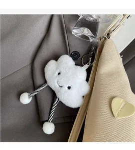 Dettaglio charm nuvola in peluche bianco con cordoncini a righe su borsa shopper