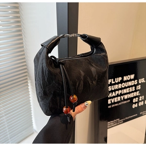 Nahaufnahme der gefalteten Dumpling-Tasche aus Leder mit silbernem Verschluss und Perlen