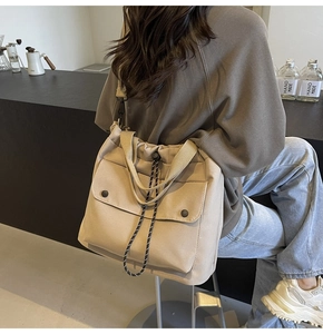 Détail d'un sac cabas en toile beige avec bandoulières réglables dans un décor décontracté