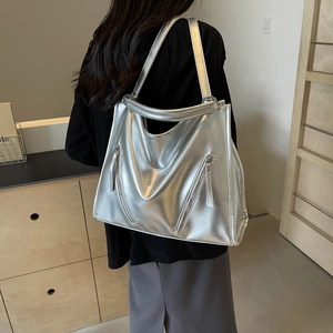 Detail view of large silver tote bag with dual zippers shown on model for size and style