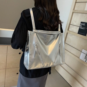 Rear view of model wearing a large silver metallic tote bag with double shoulder straps