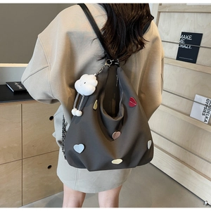 Dettaglio borsa grigio scuro con cuori 3D colorati e ciondolo a nuvola bianca