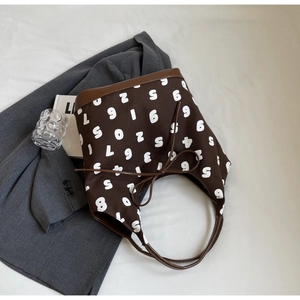 Close-up of retro brown canvas tote featuring white number print and leather handles