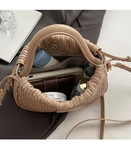 Vue de l'intérieur du sac seau plissé abricot montrant sa grande capacité et ses poches