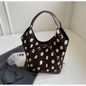 Detail of dark brown tote bag with white number prints and stylish bow knot decor